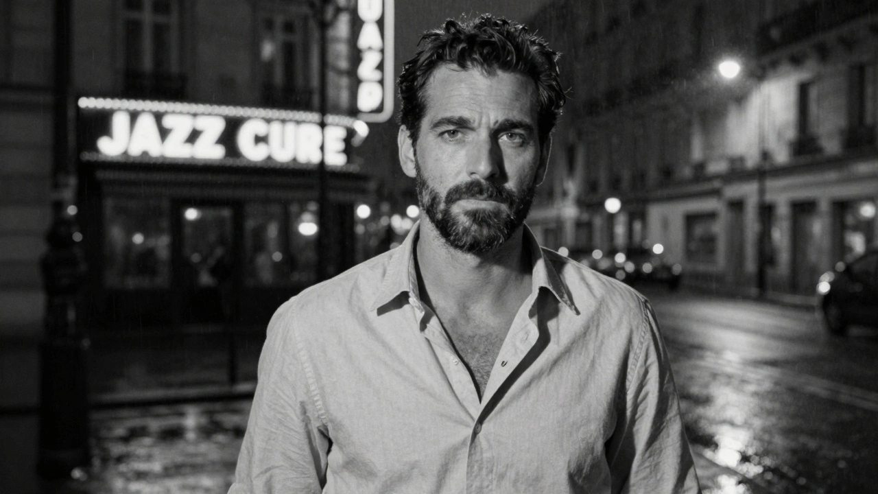 Portrait en noir et blanc d'un homme mûr, regard direct, manteau sur une chaise, lumière de rue humide en arrière-plan.