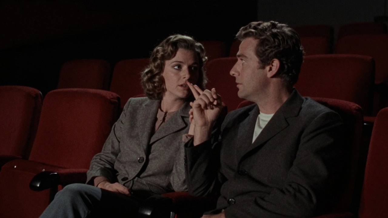 Un couple dans une salle de cinéma obscure, éclairé seulement par la lueur du projecteur.